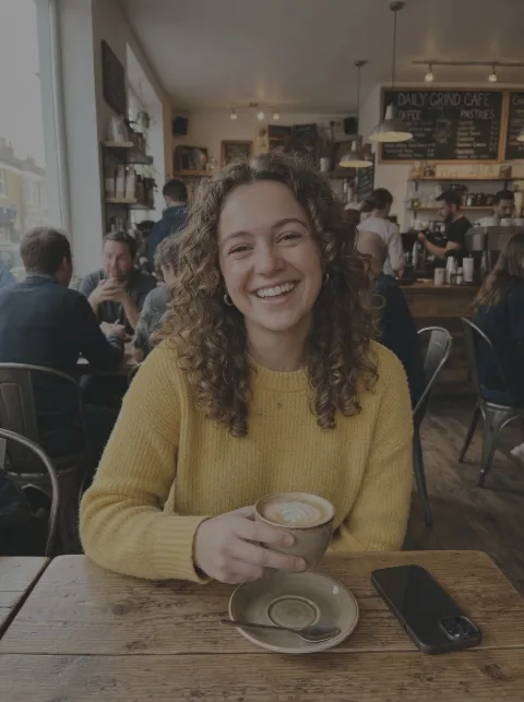 A dark, dull photo of a woman in a café